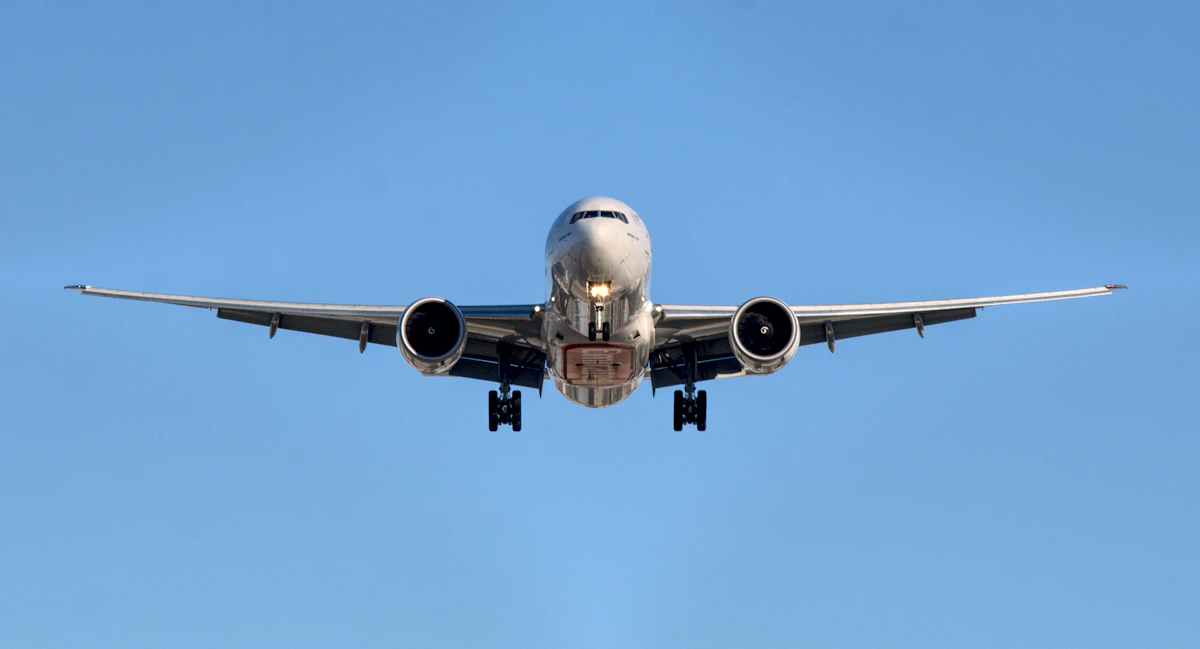 An airliner on approach against a clear blue sky