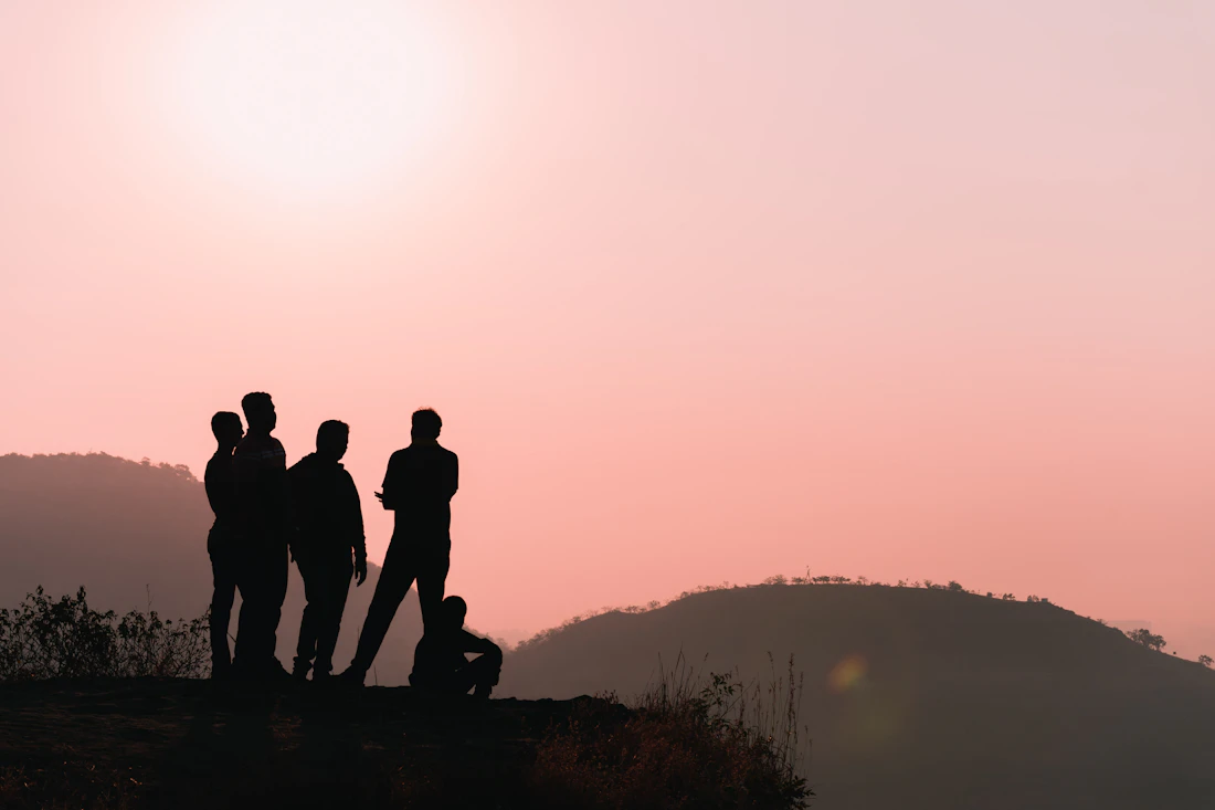 Students on a hilltop at sunset