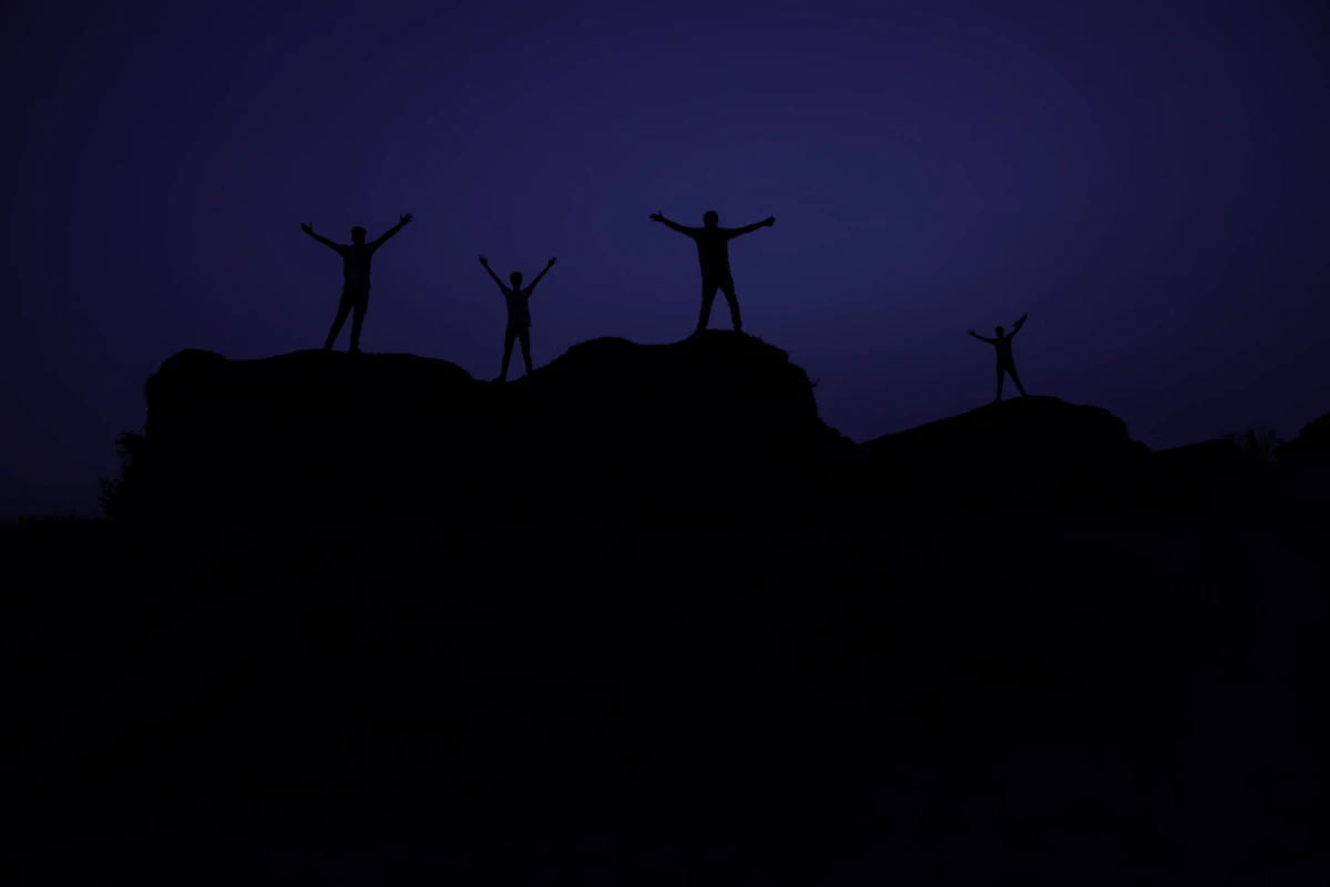 Students celebrating on a hilltop at dusk